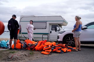 Local resident Sue Dewey (right), 68, collects some of the discarded life jackets at Eastney Point